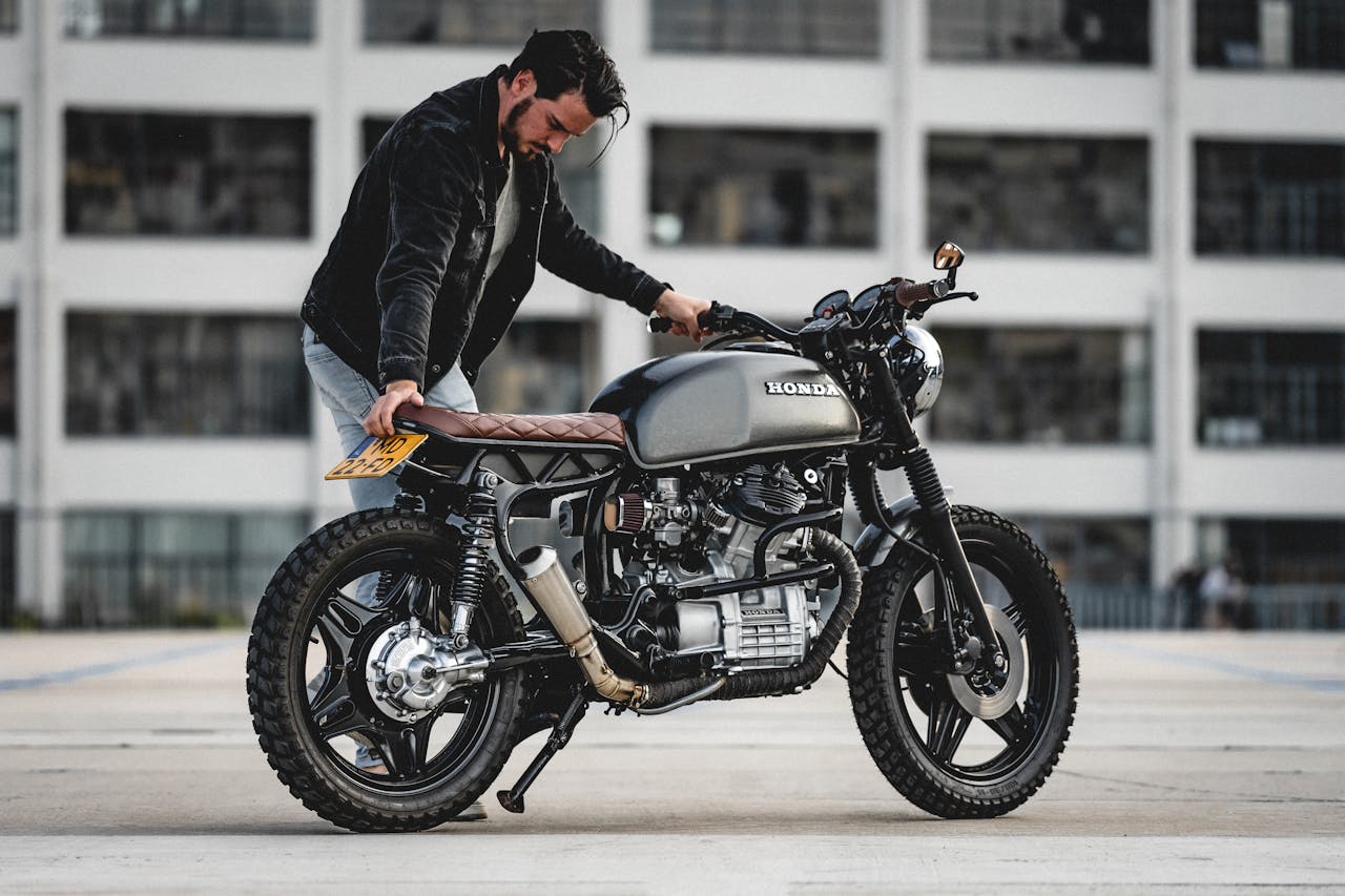 Man standing next to a custom Honda cafe racer motorcycle in Eindhoven.